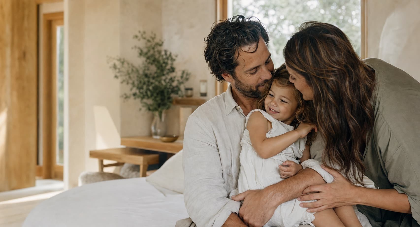 A mother and father sharing a quiet moment with their young daughter at home